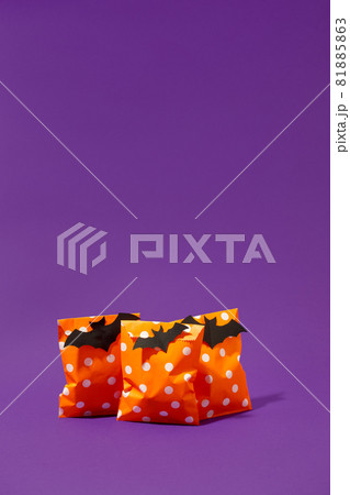 Halloween holiday concept with party gift paper bag decor and candy corn on bright violet purple backgtound, copy space, invitation, flyer, hard shadow, trendy concept Halloween holiday concept with party gift paper bag decor and candy corn on bright violet purple backgtound, copy space, invitation, flyer, hard shadow, trendy concept 81885863