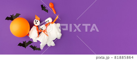 Halloween paper decorations on bright purple violet background. Black bats, ghosts, balloons. Halloween concept. Flat lay, top view, overhead. Party greeting card, invitation, flyer, banner 81885864
