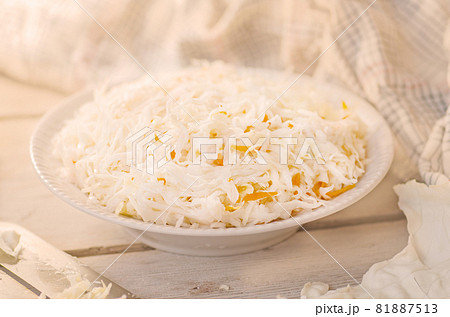 Cabbage slices and special cutter. Chopping cabbage on table. 81887513