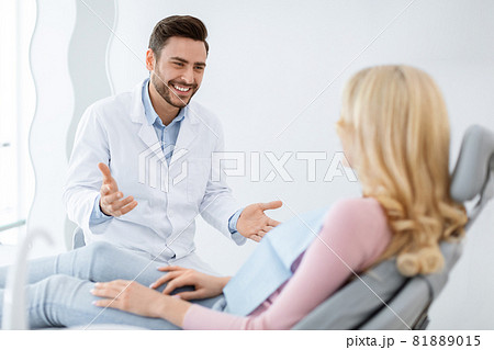 Friendly dentist having conversation with blonde woman patient Friendly dentist having conversation with blonde woman patient 81889015