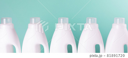 Row of white plastic bottles against a mint color background. Chemical household product for laundry and disinfection, no name. Row of white plastic bottles against a mint color background. Chemical household product for laundry and disinfection, no name. 81891720