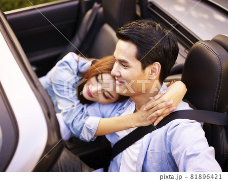 loving young asian couple riding in a convertible sports car 81896421
