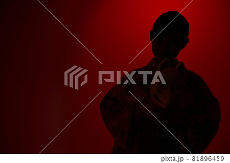 狐の面を手に持つ浴衣の女性 81896459