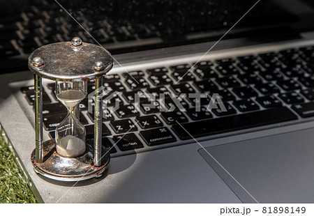 Hourglass on laptop keyboard. Time management concept. Hourglass on laptop keyboard. Time management concept. 81898149