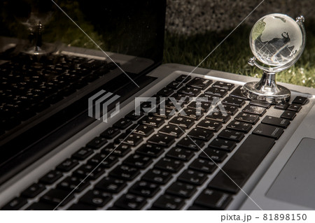 Glass crystal globe on Laptop keyboard. 81898150
