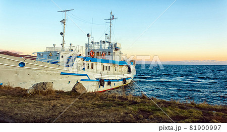 The ship is moored on the shore of Lake Baikal. Autumn landscape. The nature of Eastern Siberia. At sunset. 81900997