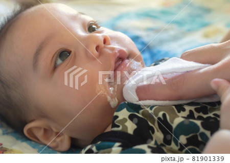 asian mother is wiping her baby's face after infant baby boy vomiting with soft sunbeam. people and family lifestyle concept. asian mother is wiping her baby's face after infant baby boy vomiting with soft sunbeam. people and family lifestyle concept. 81901339
