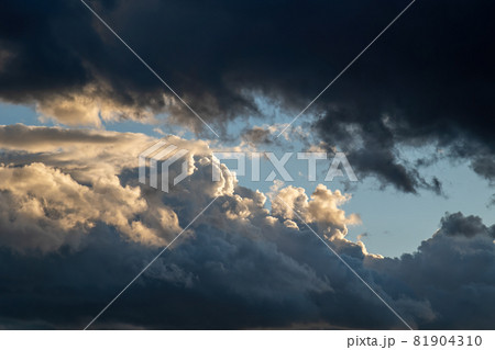 Heavy dark clouds at the sunset. Dramatic sky cloudscape lighted with setting sun. 81904310
