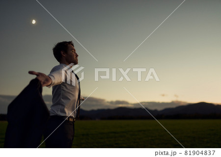 Young businessman meditating in nature 81904837