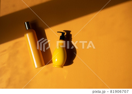 Mockup of yellow cosmetic bottles with shadow monstera leaves on yellow background. A creative, minimalistic shot of a cosmetic product. The concept of summer, natural cosmetics. Flat Lay. Mockup of yellow cosmetic bottles with shadow monstera leaves on yellow background. A creative, minimalistic shot of a cosmetic product. The concept of summer, natural cosmetics. Flat Lay. 81906707