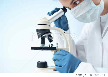 laboratory assistant wearing a medical mask looking through a microscope Professional research experiment laboratory assistant wearing a medical mask looking through a microscope Professional research experiment 81908084