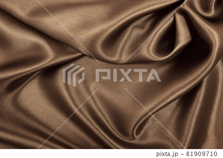 Smooth elegant brown silk or satin texture as abstract background. Luxurious background design. In Sepia toned. Retro style Smooth elegant brown silk or satin texture as abstract background. Luxurious background design. In Sepia toned. Retro style 81909710
