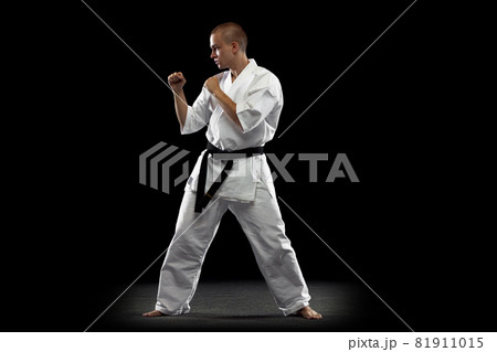 Full-length image of young sportsman practising karate isolated over black background Full-length image of young sportsman practising karate isolated over black background 81911015