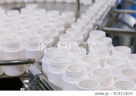 white plastic bottle on the production line of the conveyor at filling machine in the medical factory. selective focus. white plastic bottle on the production line of the conveyor at filling machine in the medical factory. selective focus. 81912824