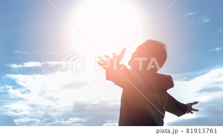 Freedom and feel good concept. Copy space of silhouette man rising hands on sunset sky background. 81913761