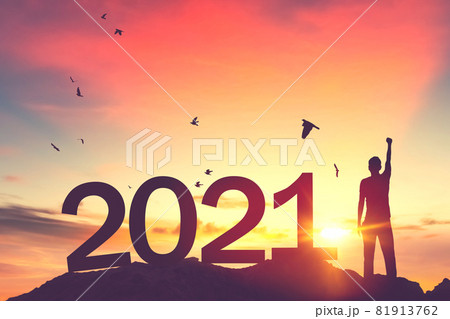 Man raise hand up on sunset sky with birds flying at top of mountain and number like 2021 abstract background. Happy new year and holiday concept. Man raise hand up on sunset sky with birds flying at top of mountain and number like 2021 abstract background. Happy new year and holiday concept. 81913762