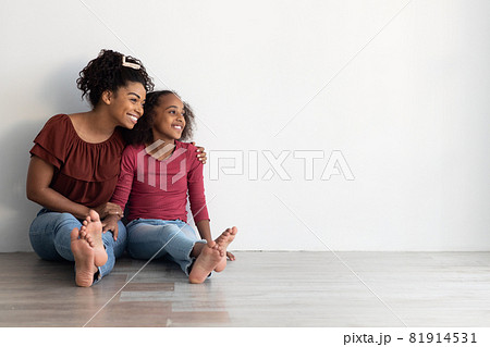 Cheerful black mother and daughter looking at copy space 81914531