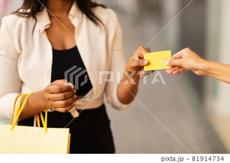 Unrecognizable black female giving credit card to seller 81914734