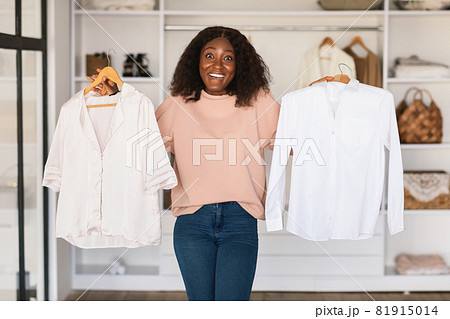 Black Lady Shopaholic Holding Shirts Choosing Buying Clothes In Store Black Lady Shopaholic Holding Shirts Choosing Buying Clothes In Store 81915014