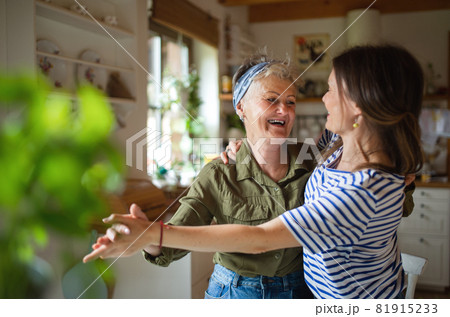 Happy senior mother having fun with adult daughter indoors at home, dancing. Happy senior mother having fun with adult daughter indoors at home, dancing. 81915233
