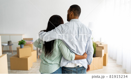 Back view of black husband and wife cuddling while moving to new house, panorama with free space, panorama 81915234
