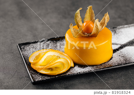 Yellow mousse dessert decorated with physalis Yellow mousse dessert decorated with physalis 81918324