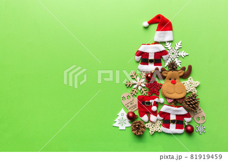 Christmas tree made from colored suit santa decoration on colored background, view from above. New Year minimal concept with copy space Christmas tree made from colored suit santa decoration on colored background, view from above. New Year minimal concept with copy space 81919459