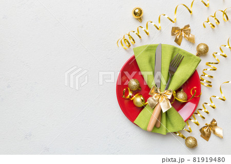 Christmas table place setting with christmas decor and plates, kine, fork and spoon. Christmas holiday background. Top view with copy space Christmas table place setting with christmas decor and plates, kine, fork and spoon. Christmas holiday background. Top view with copy space 81919480