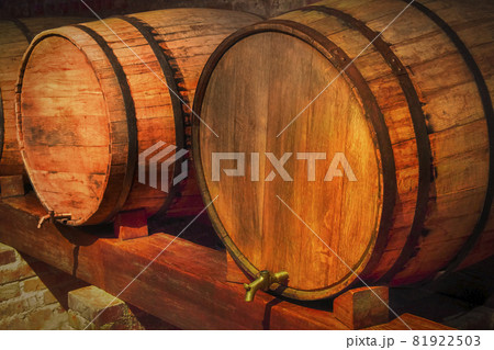 Old barrels of wine in a dark basement Old barrels of wine in a dark basement 81922503