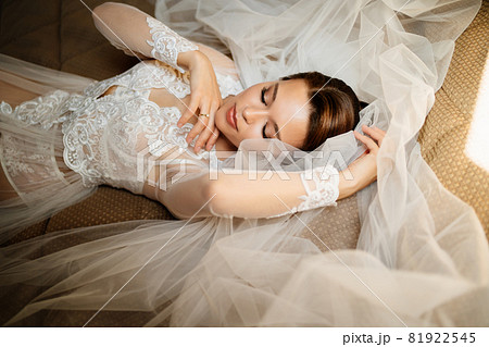 a gentle bride in a lace robe lies in bed on a veil. morning before the wedding. 81922545