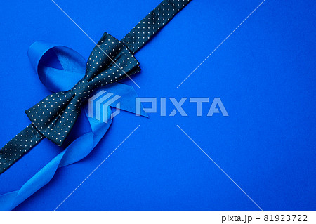 Prostate awareness. Blue ribbon, fashion bowtie isolated on deep blue background. Awareness prostate cancer of men health in November. Healthcare, International men, Father day. 81923722