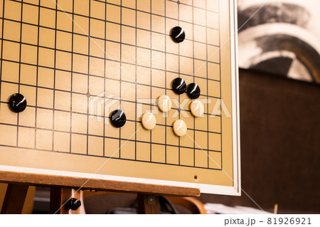 囲碁の大盤で小目からの一間飛びをした白を黒が追い詰めて、死活の勝負をしている図 囲碁の大盤で小目からの一間飛びをした白を黒が追い詰めて、死活の勝負をしている図 81926921