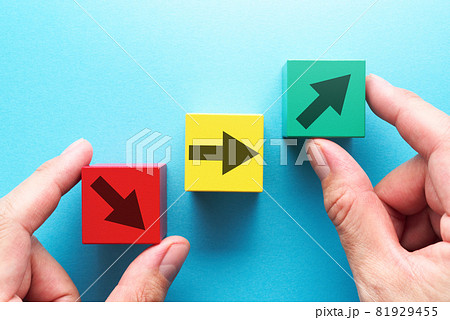 上向き、下向き、水平の矢印が描かれた3つの積木を持つ手。 上向き、下向き、水平の矢印が描かれた3つの積木を持つ手。 81929455