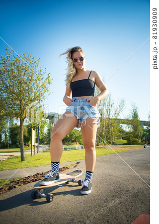 Beautiful young woman with skateboard 81930909
