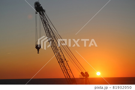 Sunset with a construction crane on the sea Sunset with a construction crane on the sea 81932050