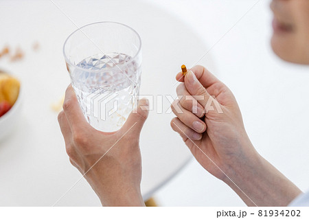 カプセル剤を水で飲もうとする男性 81934202