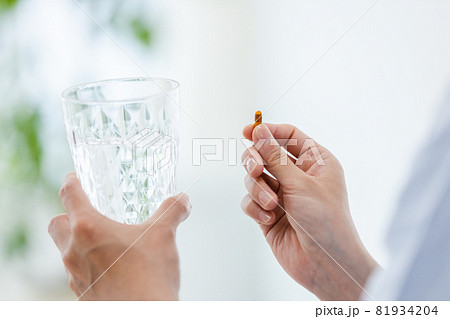 カプセル剤を水で飲もうとする男性 81934204
