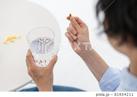 カプセル剤を水で飲もうとする男性 81934211