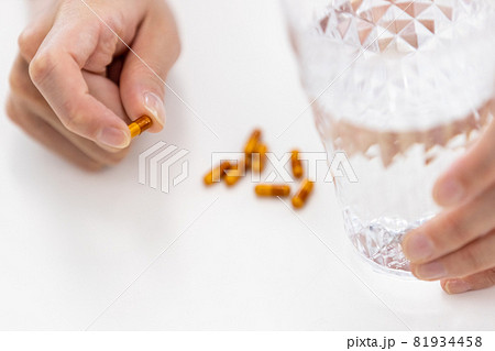 カプセル剤を飲もうとする男性の手元 81934458