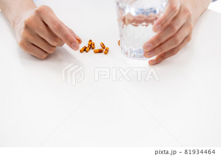 カプセル剤を飲もうとする男性の手元 81934464