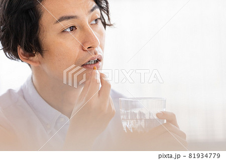 カプセル剤を水で飲もうとする男性 カプセル剤を水で飲もうとする男性 81934779