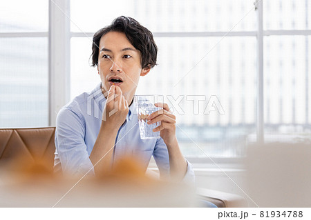 カプセル剤を水で飲もうとする男性 81934788
