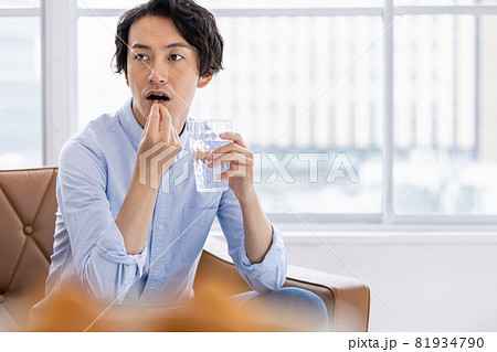 カプセル剤を水で飲もうとする男性 81934790