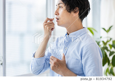 カプセル剤を水で飲もうとする男性 81934792