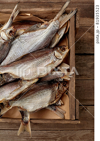 Salted air-dried roach in crate on wooden background 81935523