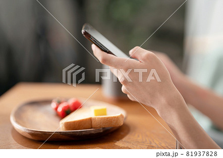 若い男性　スマートフォン　朝食　手元 81937828