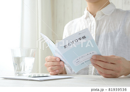 模造品のおくすり手帳を確認する女性 81939536