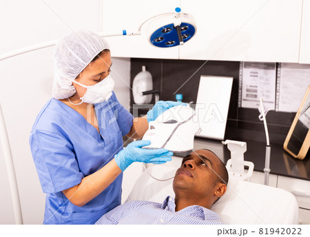 Male client getting face phototherapy procedure in clinic Male client getting face phototherapy procedure in clinic 81942022