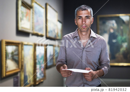 Man is looking at the exposition with brochure Man is looking at the exposition with brochure 81942032