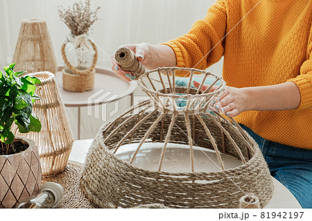 Woman makes handmade diy lamp from jute rope Woman makes handmade diy lamp from jute rope 81942197
